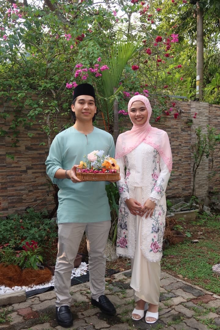 Mia and Arief outdoors with the flower basket
